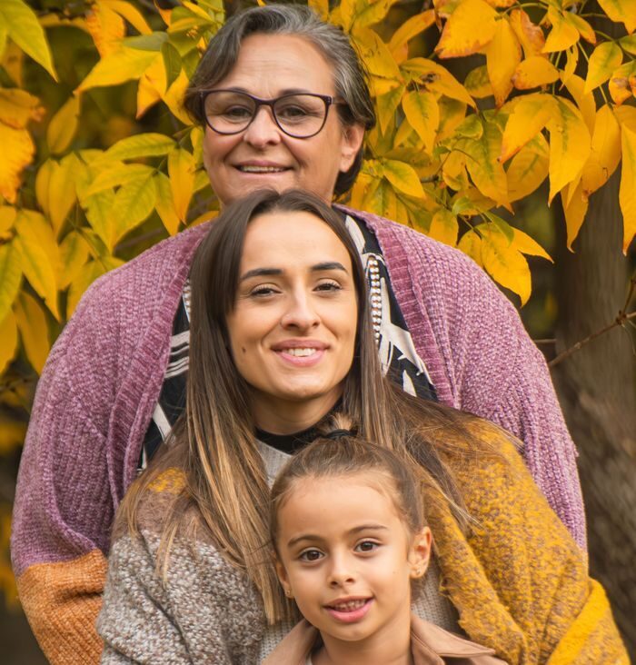 Adult child sitting between two generations, balancing caregiving roles
